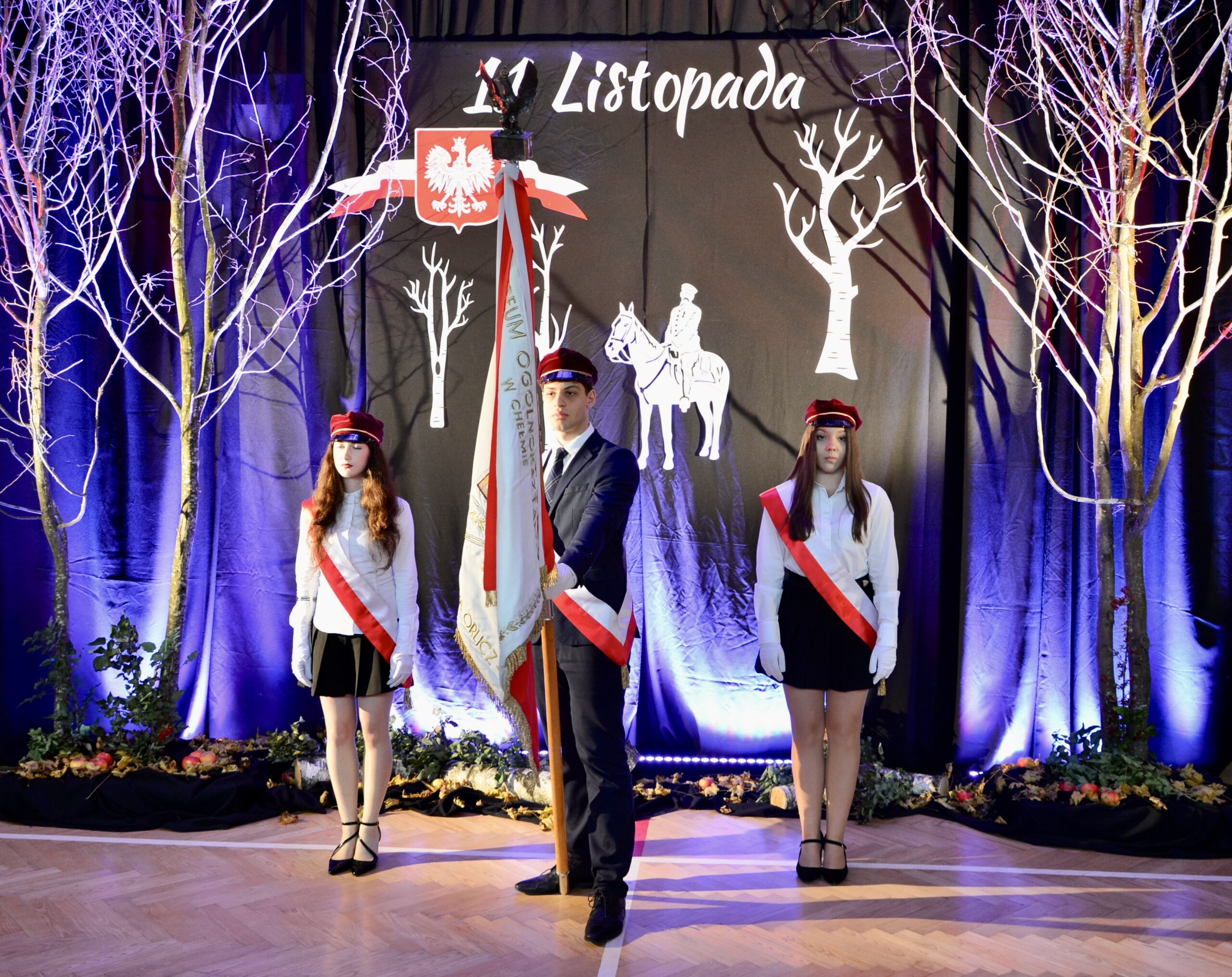 Na zdjęciu poczet sztandarowy na tle dekoracji z okazji Święta Niepodległości